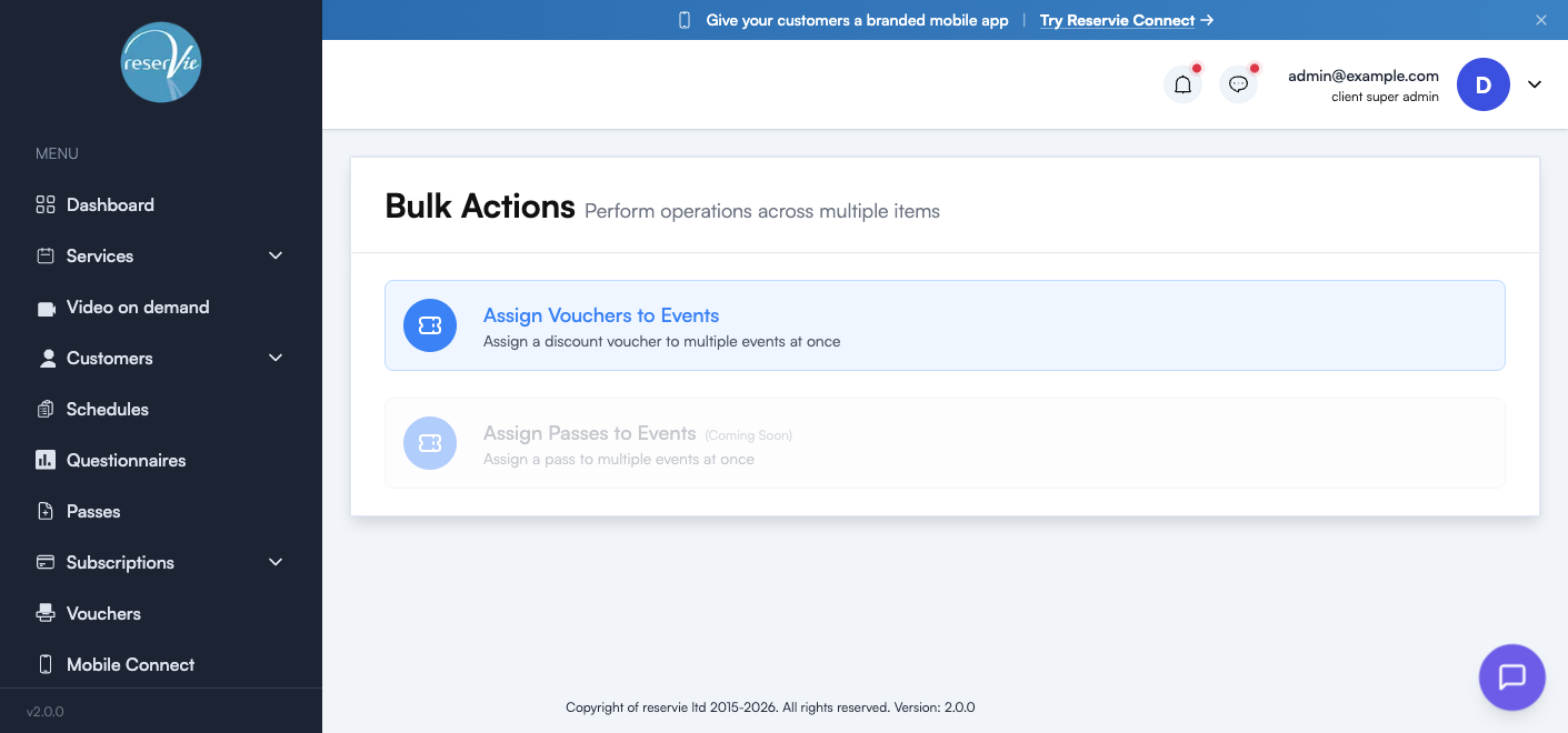 Bulk Actions hub showing the page title "Perform operations across multiple items" and two action cards: Assign Vouchers to Events (active) and Assign Passes to Events (Coming Soon)